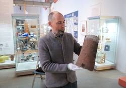 Museumsleiter Tobias Müller präsentiert einen historischen Ziegel