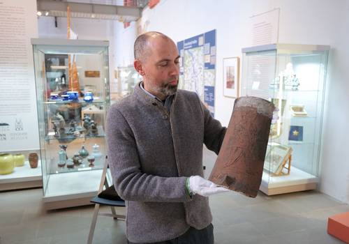Museumsleiter Tobias Müller präsentiert einen historischen Ziegel