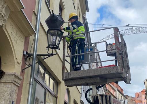Mann tauscht Lampe auf der Burgstraße aus