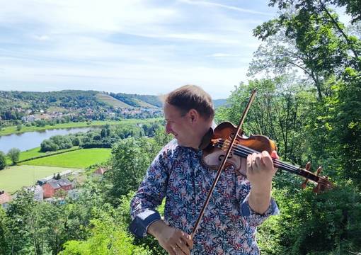 Geiger Florian Mayer vor Ausblick auf Stadt- und Elblandschaft in Meißen