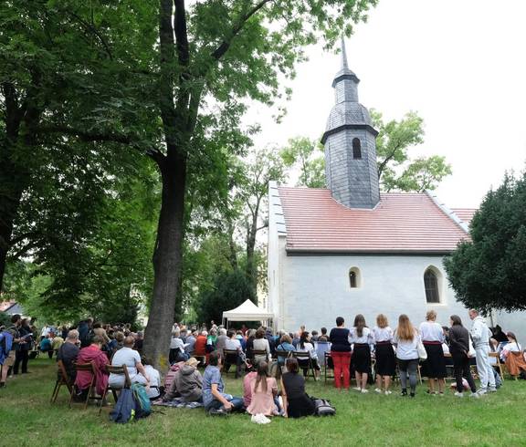 Menschen im Park vor Kirche
